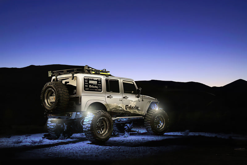 Jeep Wrangler with off-road equipment on a desert landscape with underbody lighting