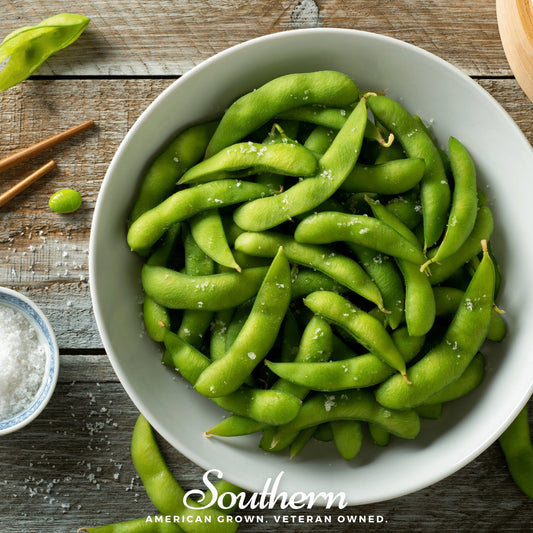 White bowl filled with green edamame on a wooden surface with 'Southern' branding.