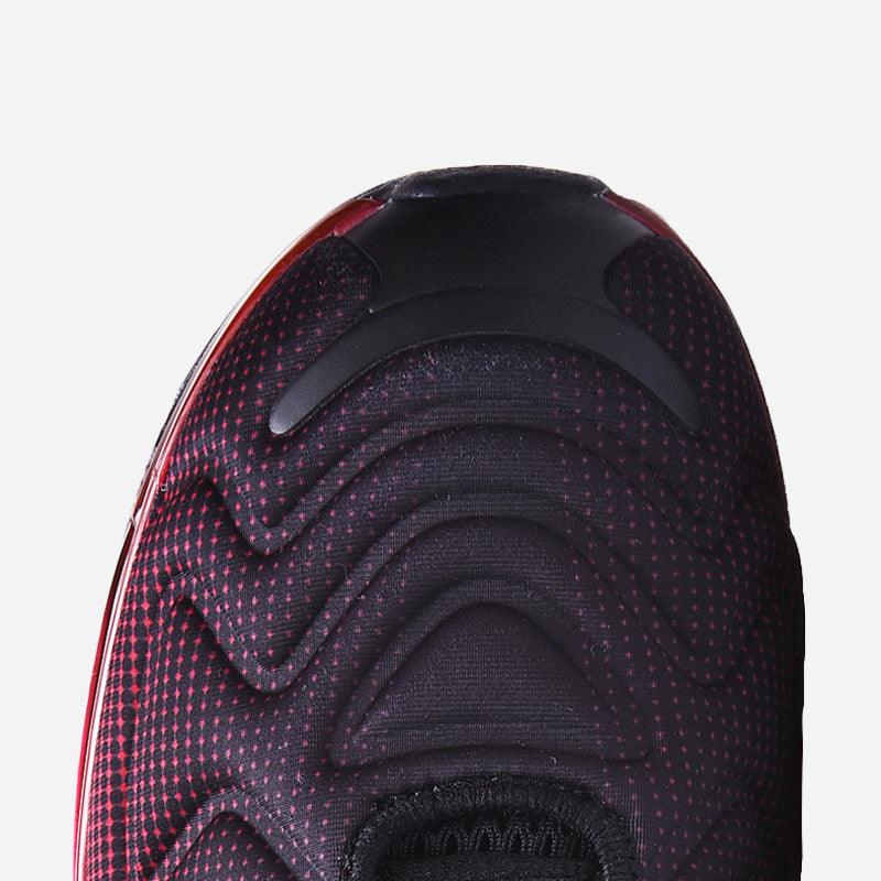 Close-up of a shoe sole with red and black pattern on a light gray background