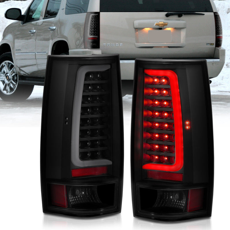 Pair of black LED Chevy Tahoe tail lights with red interior on a white background, with a silver SUV in the background.