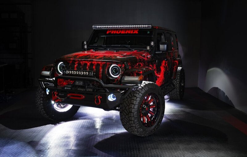Red and black off-road vehicle with custom modifications anad underbody lighting on a dark background