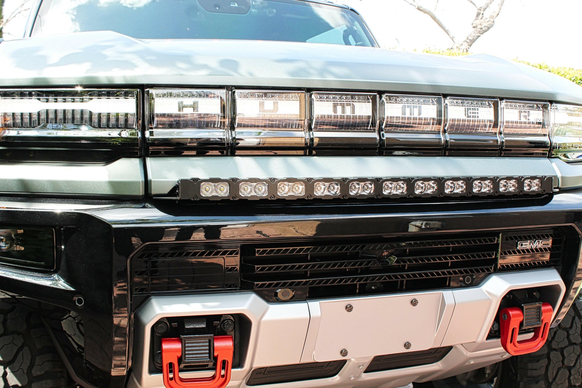 Close-up of a hummers front grille with LED lights and red accents.