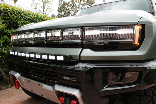 Close-up of a GMC hummers front grille with visible branding and LED light bar.