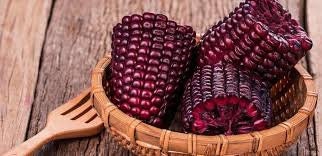 Basket of purple corn on a wooden surface