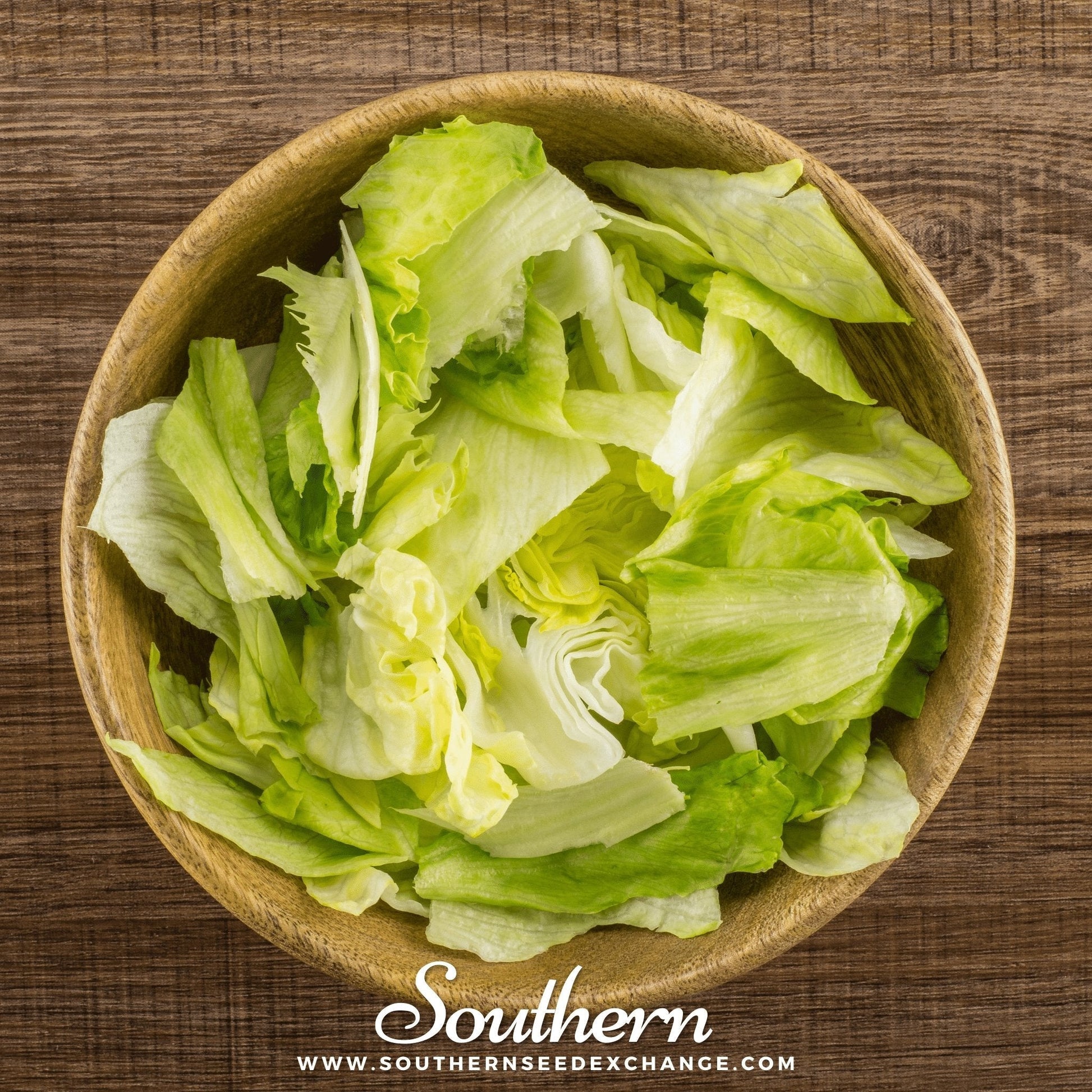 Wooden bowl filled with green leafy lettuce on a wooden surface, branded 'Southern Seed Exchange'.