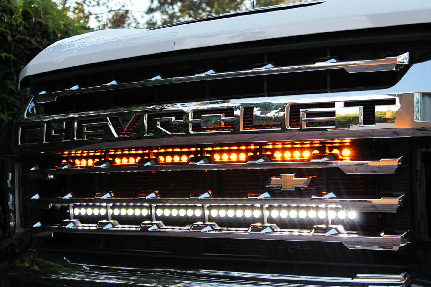 Chevrolet vehicle grille with LED lights on a blurred natural background