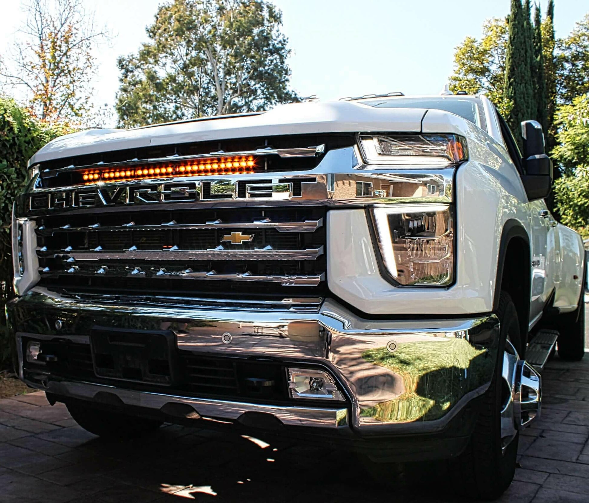 White Chevrolet truck with amber LED Light bar mounted above grille