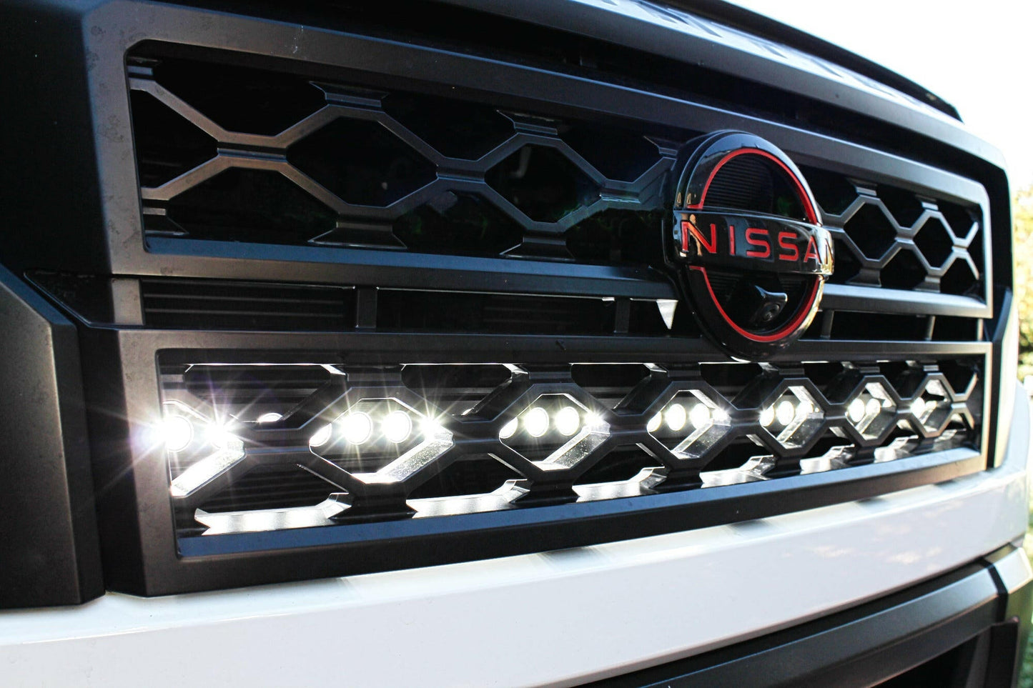 Close-up of a Nissan vehicle grille with Nissan logo and LED Light Bars.