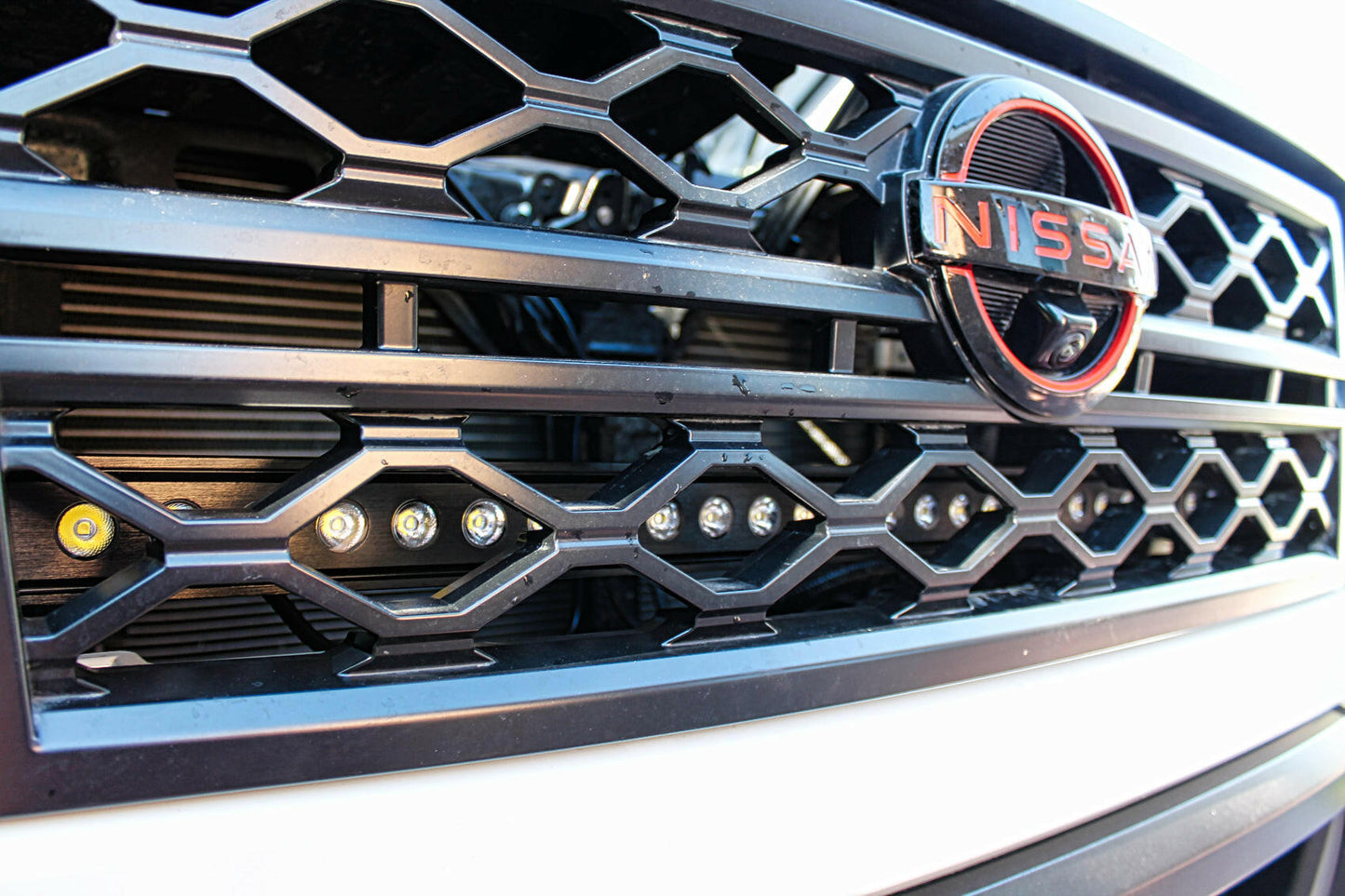 Close-up of a Nissan car grille with prominent logo and LED Light Bars