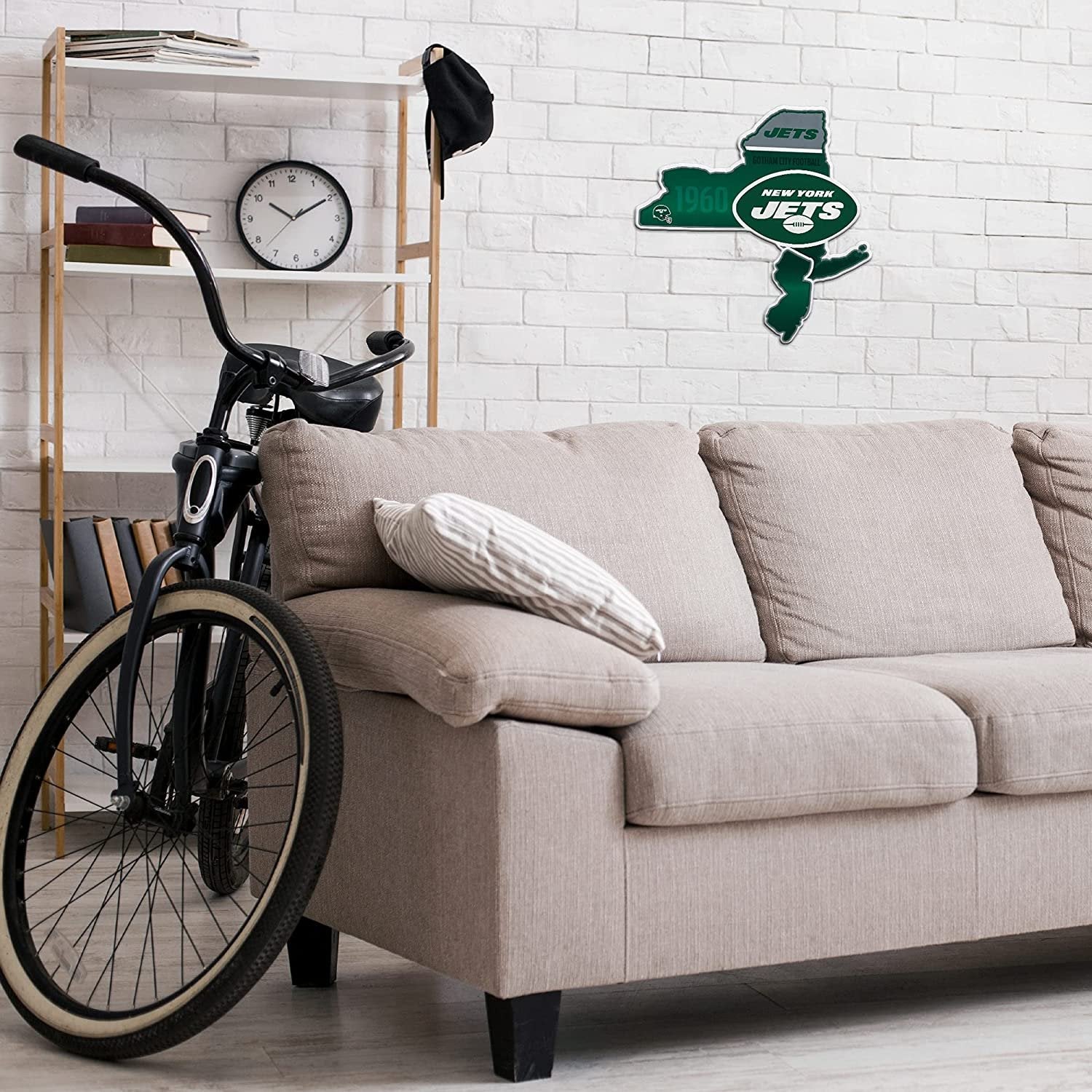 Living room with a beige sofa, bicycle, and New York Jets wall decal.
