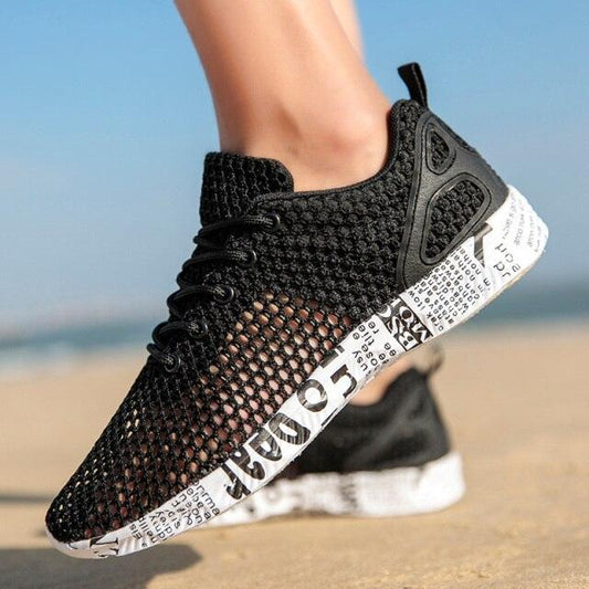 Black sneaker with white sole on a blurred beach background