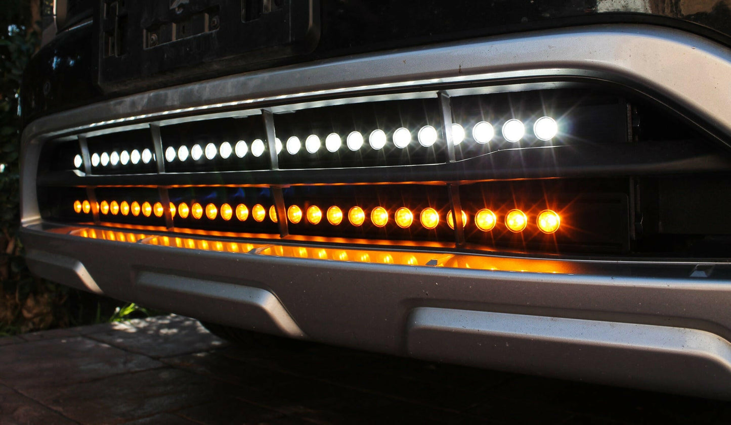 Close-up of a vehicle's front headlight with LED lights on a dark background