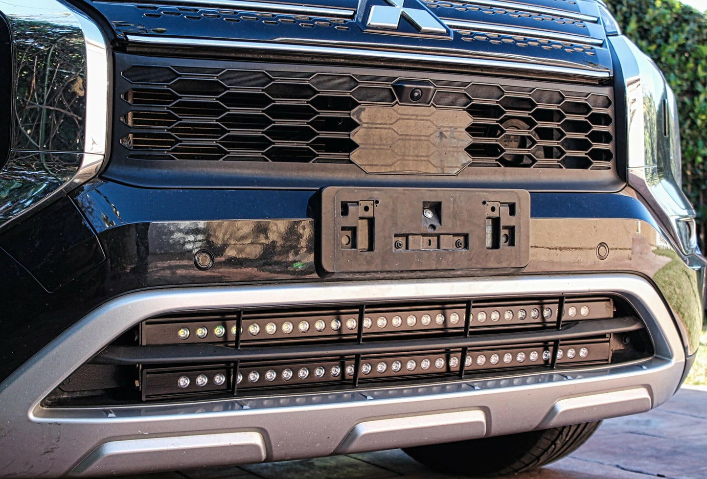 Close-up of a vehicle's front grille with LED lights.