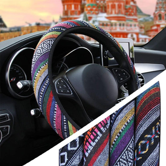 Colorful steering wheel cover on a car steering wheel with a blurred cityscape in the background