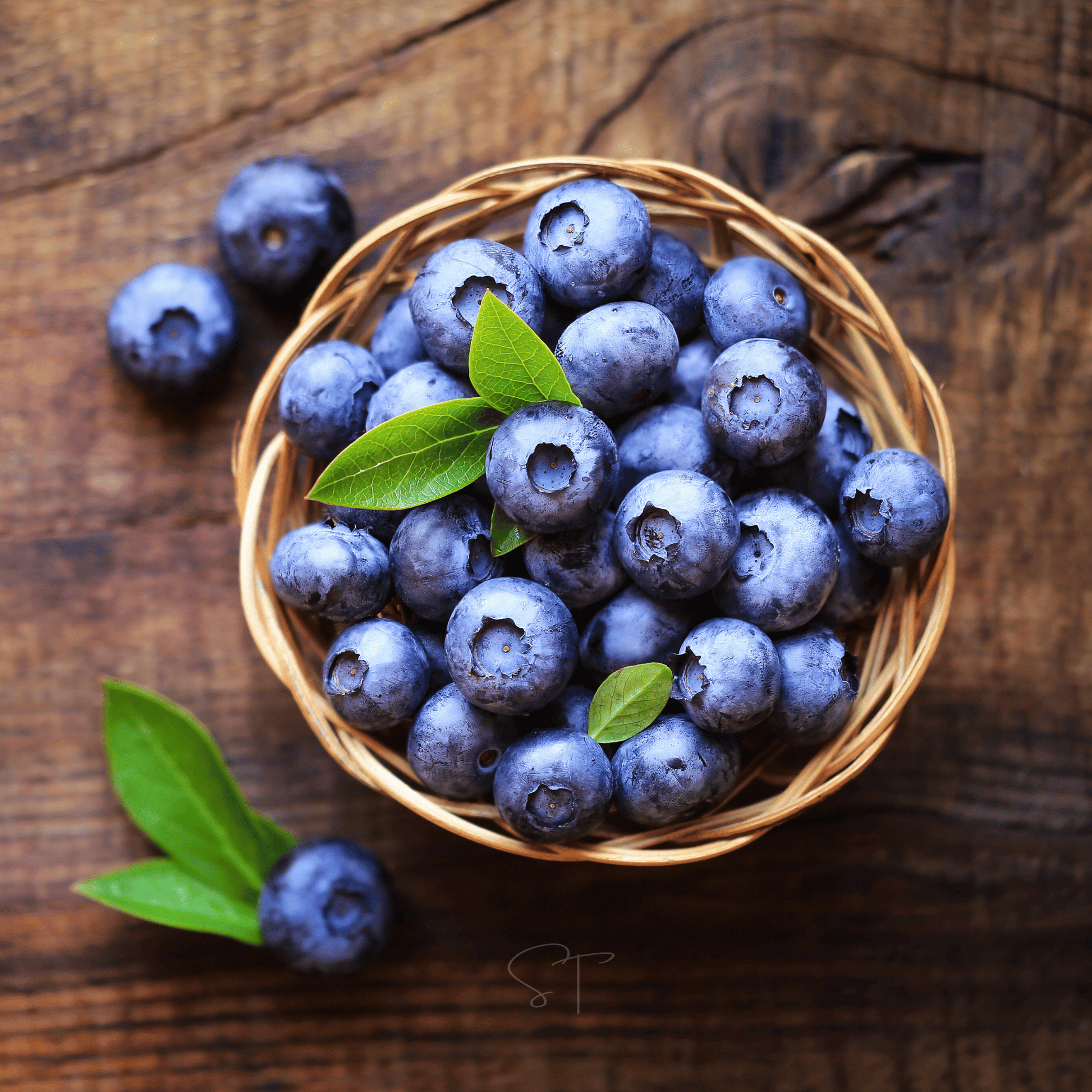 Wicker basket filled with blueberries on a wooden surface