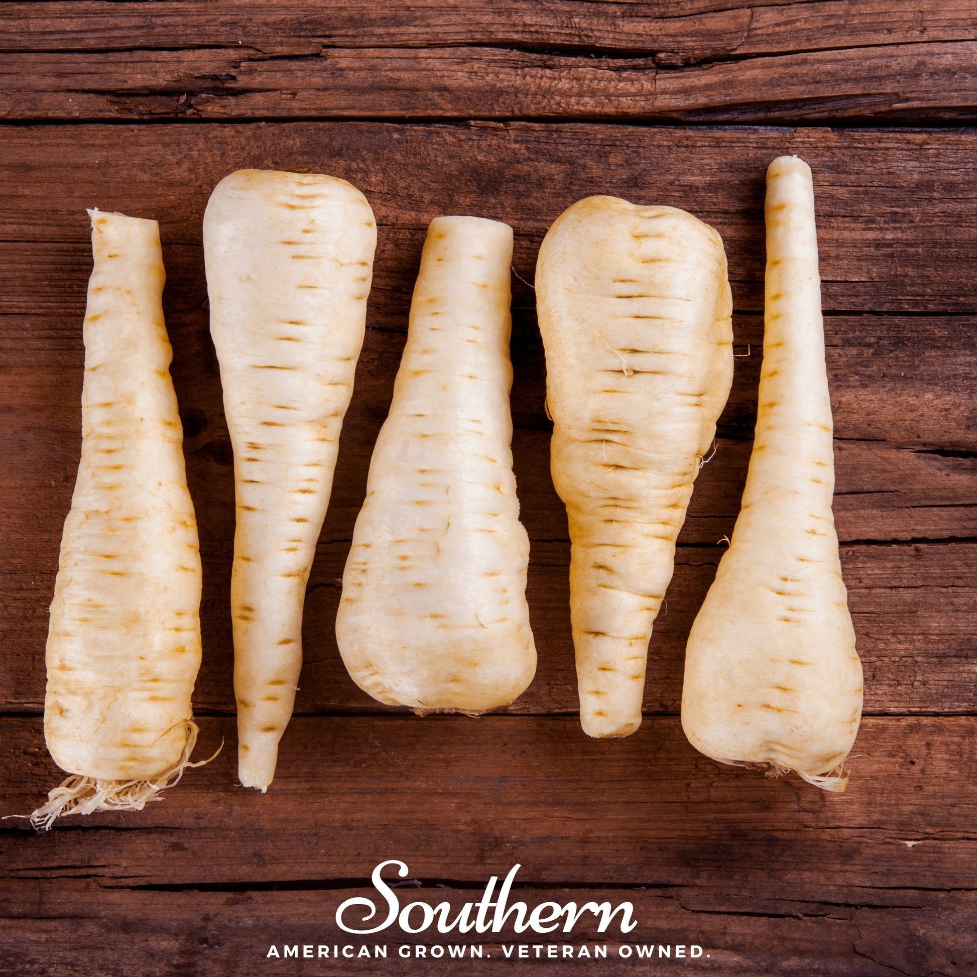 Five parsnips on a wooden surface with 'Southern' branding.