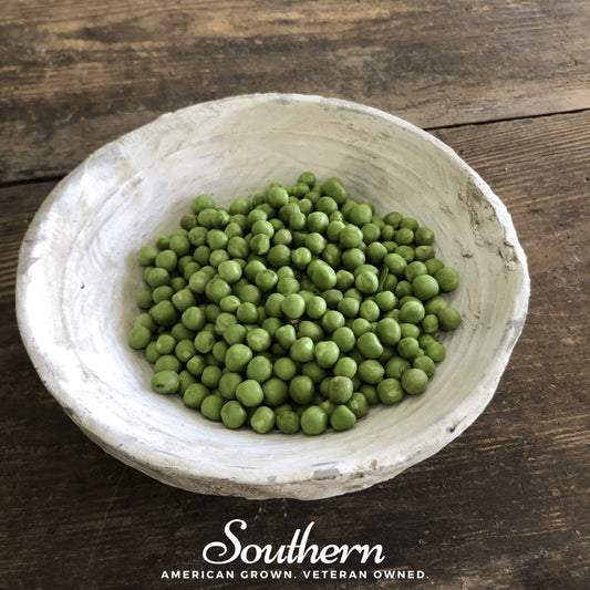 White bowl filled with green peas on a wooden surface, with 'Southern' brand text at the bottom.