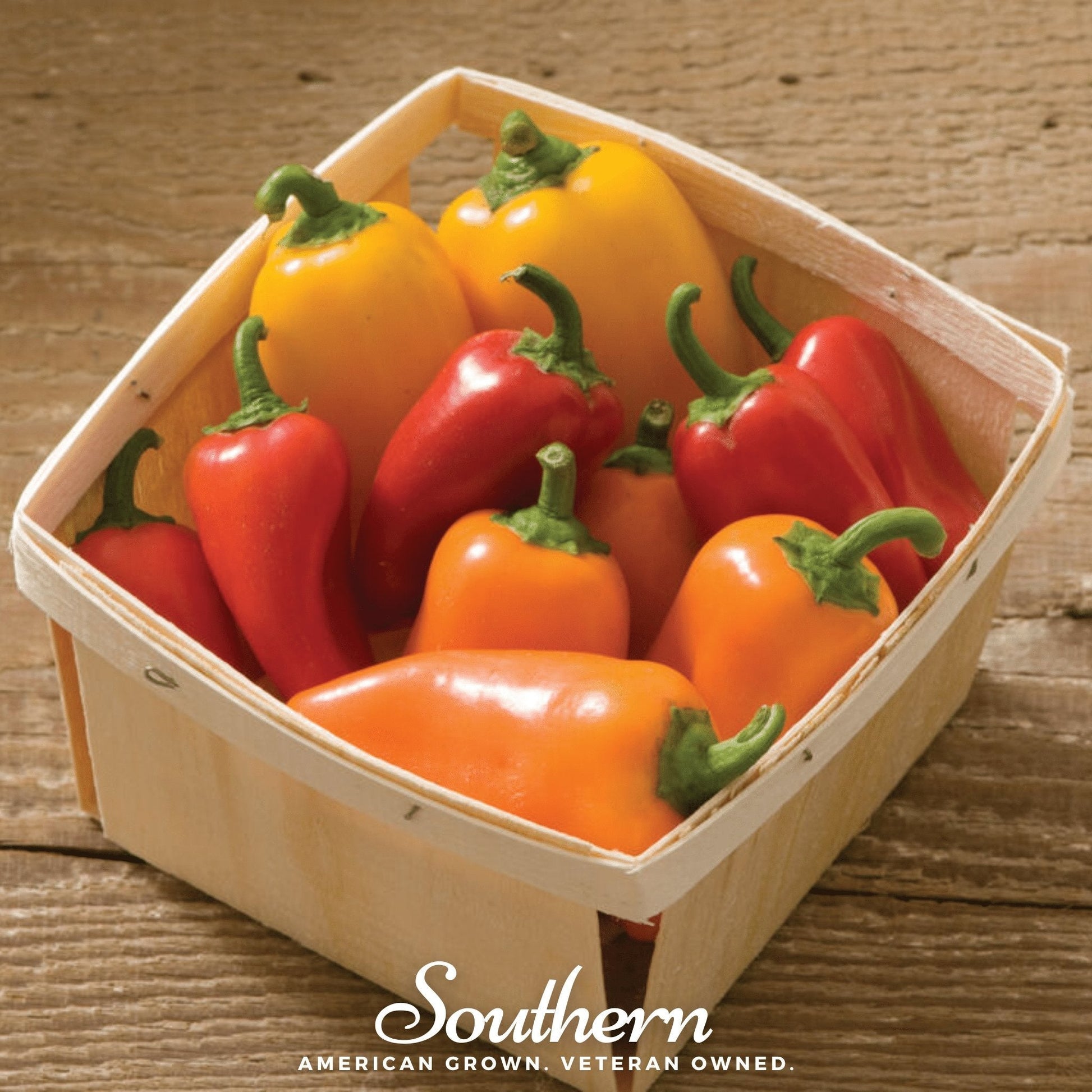 Assorted colored peppers in a wooden basket on a wooden surface with 'Southern' branding.