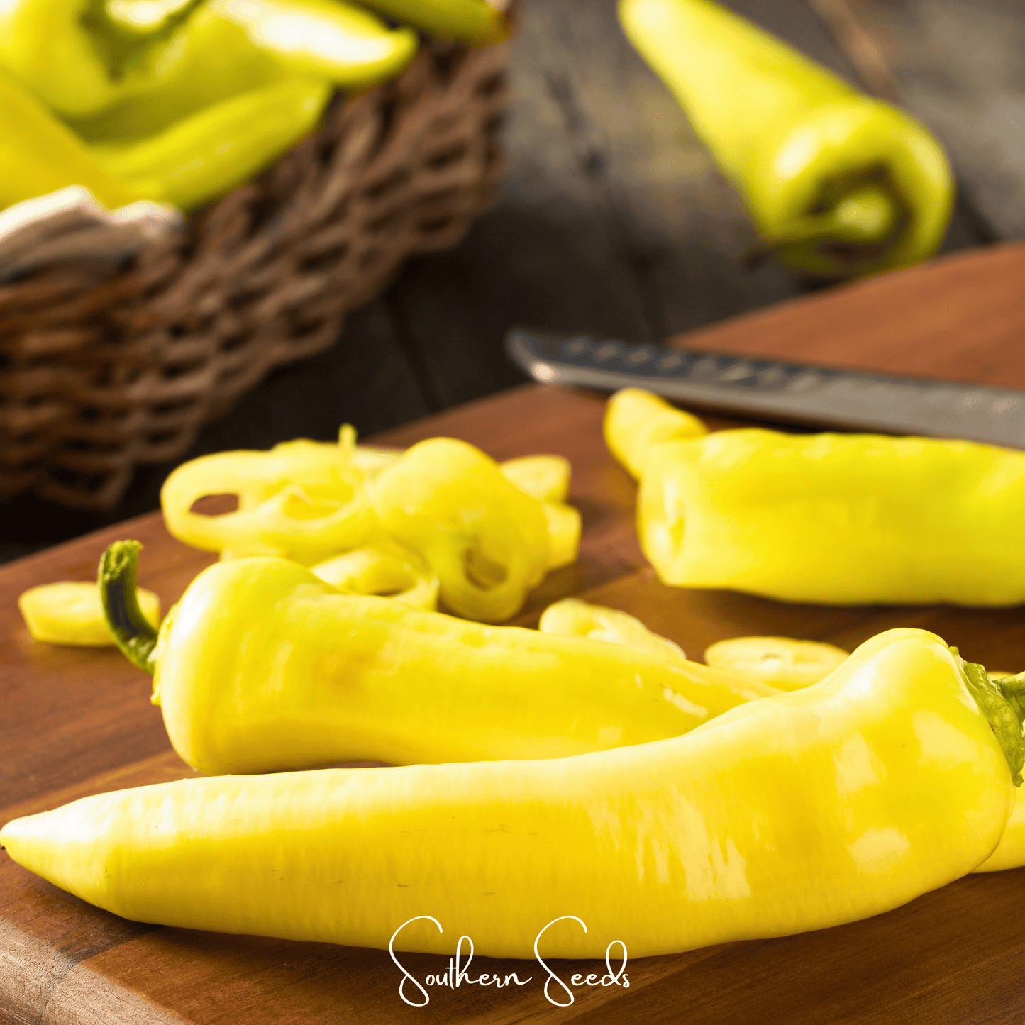 Yellow peppers on a wooden cutting board with a blurred background