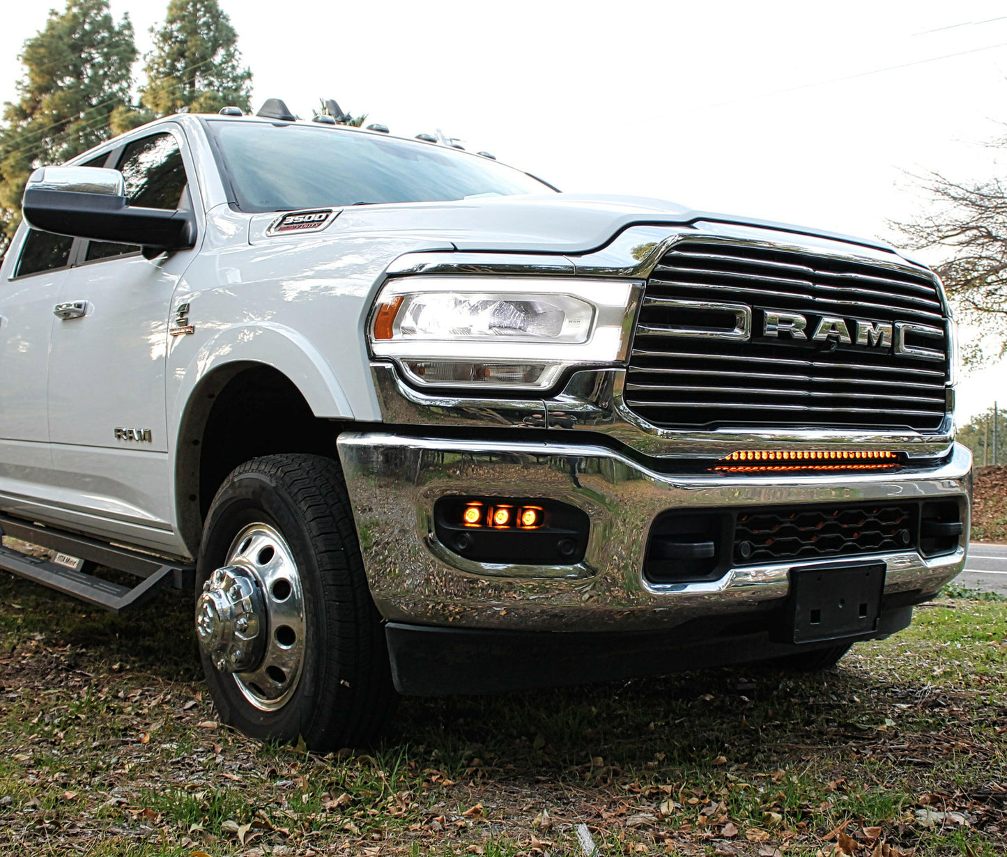 White Ram truck with LED Light Bar parked outdoors with trees in the background