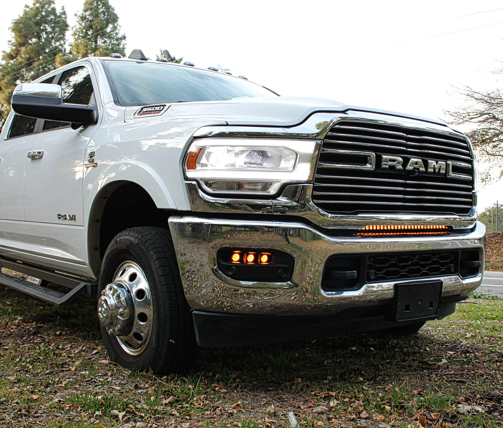 White Ram truck with LED Light Bar parked outdoors with trees in the background