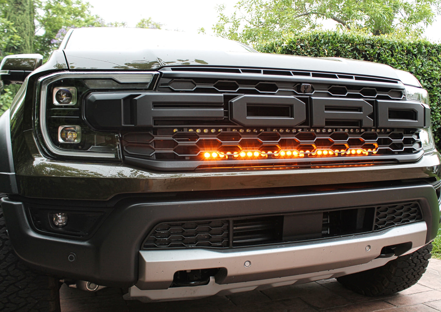 Ford truck grille with LED lights in a driveway