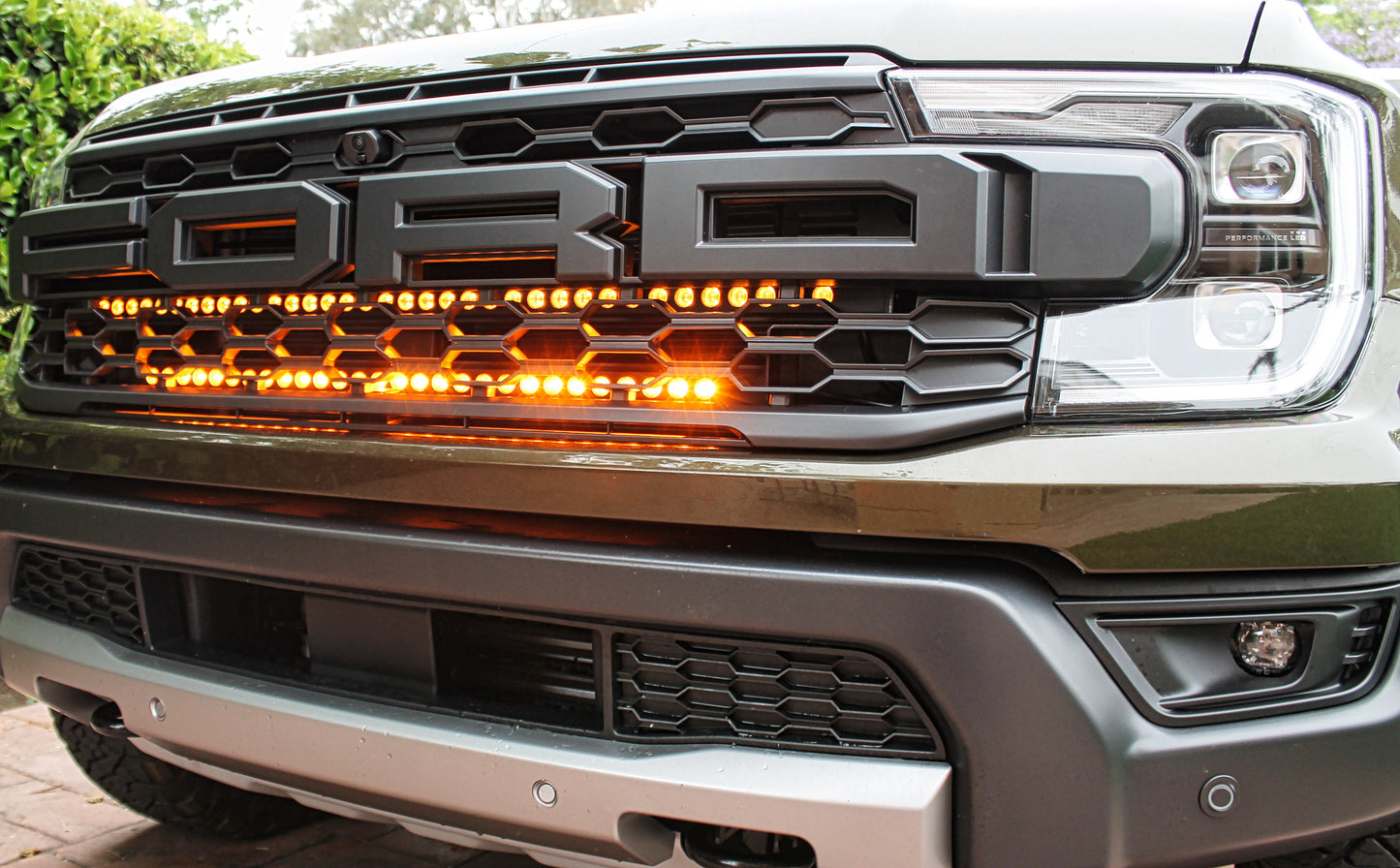Close-up of a truck grille with LED lights and 'Ford' branding.