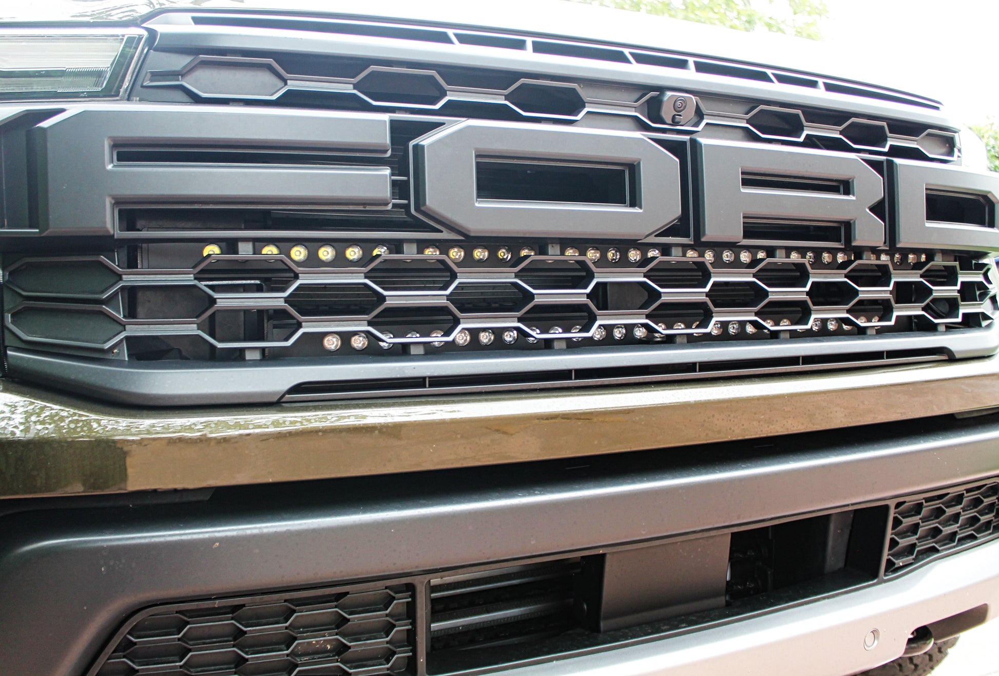 Close-up of a Ford vehicle grille with prominent 'Ford' logo.