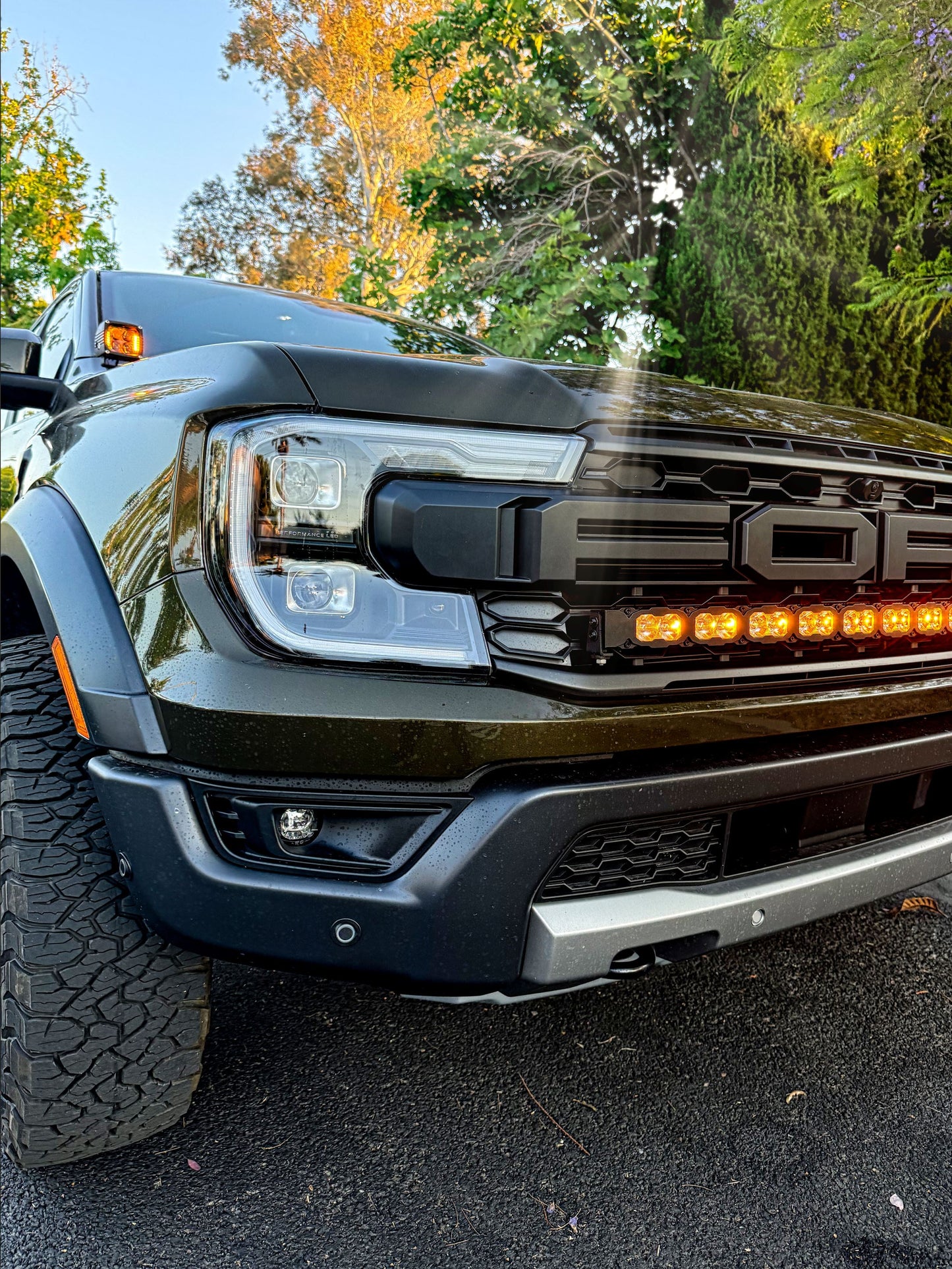 Front view of a Ford truck with amber LED Light bar and detailed headlight and grille design.