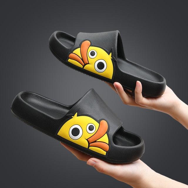 Black slides with cartoon fish design held by a hand against a dark background