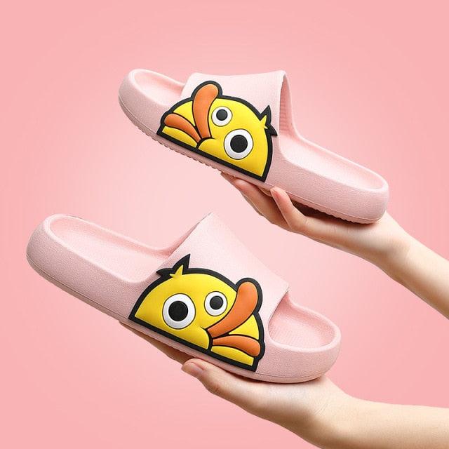 Pink slides with cartoon fish design held against a pink background