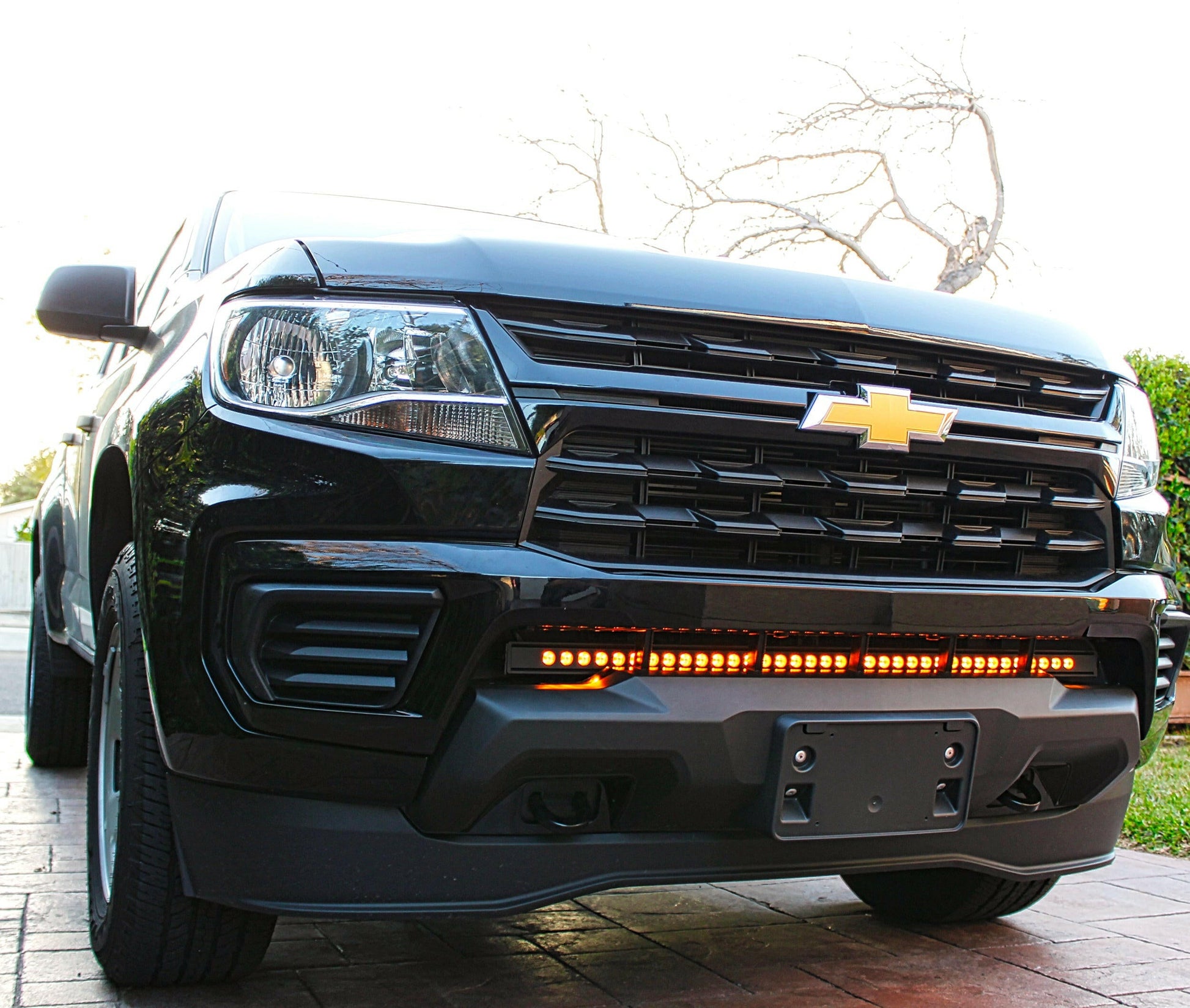 Black Chevrolet truck with LED light bar on a driveway
