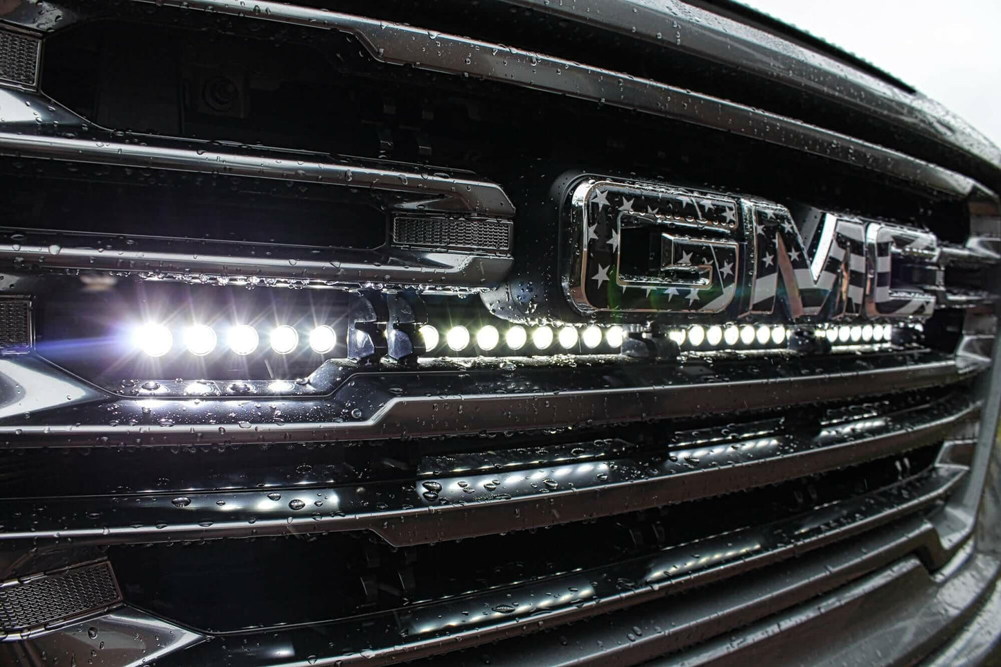 Close-up of a vehicle grille with LED lights and a brand logo.