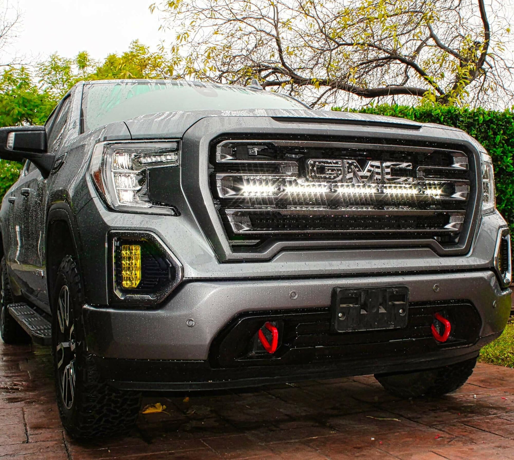 Front view of a GMC truck with LED Light Bars detailed features on a brick surface.