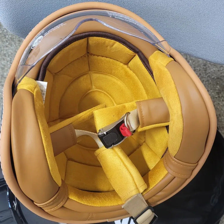 Close-up of a brown helmet with yellow interior and visible chin strap.