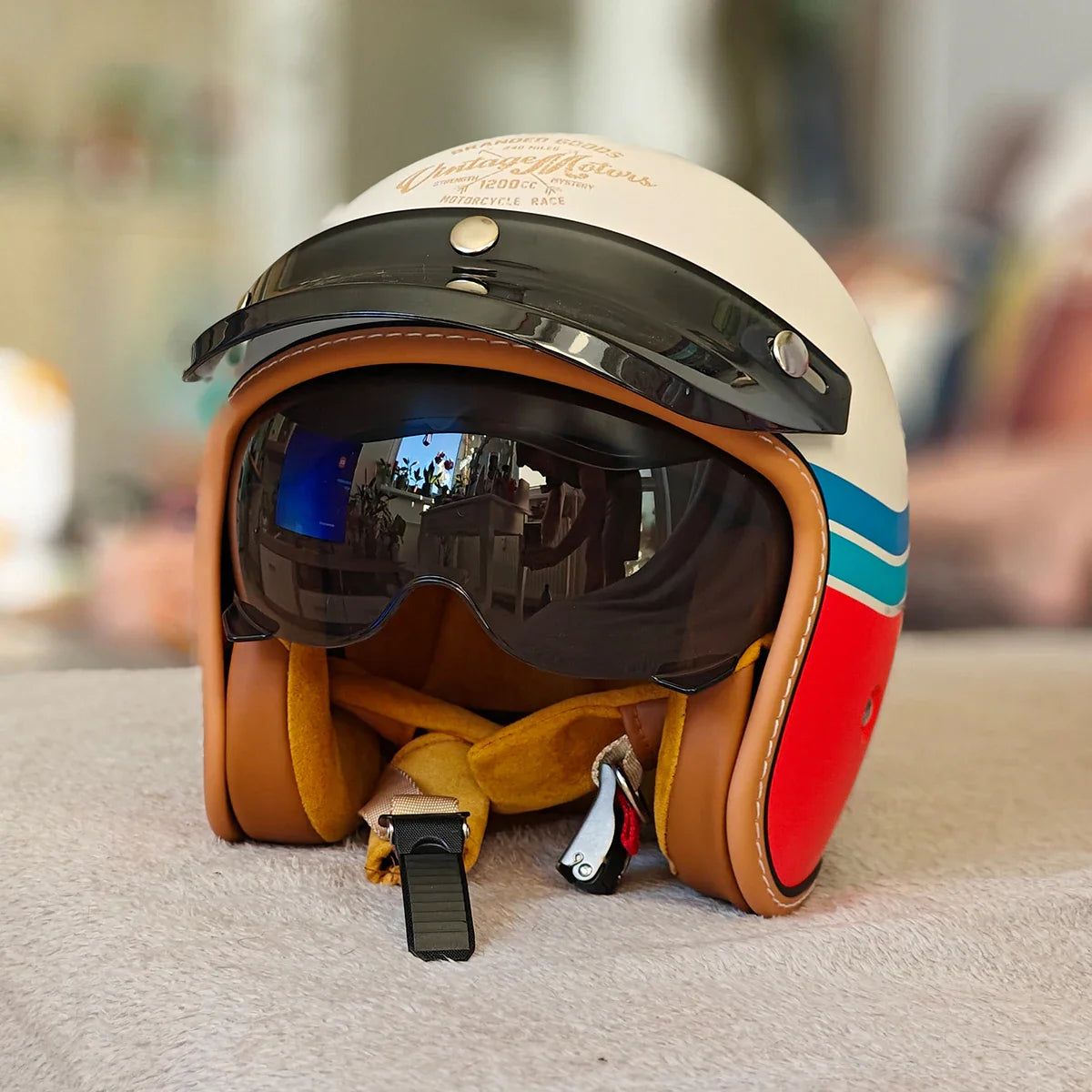 Colorful motorcycle helmet with reflective visor on a blurred background