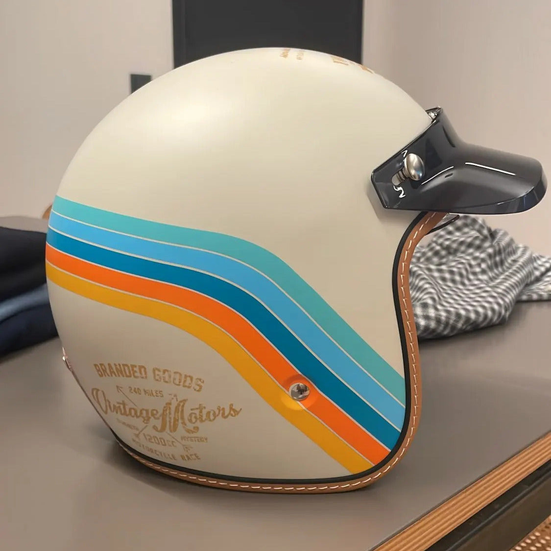 Vintage-style helmet with colorful stripes on a table