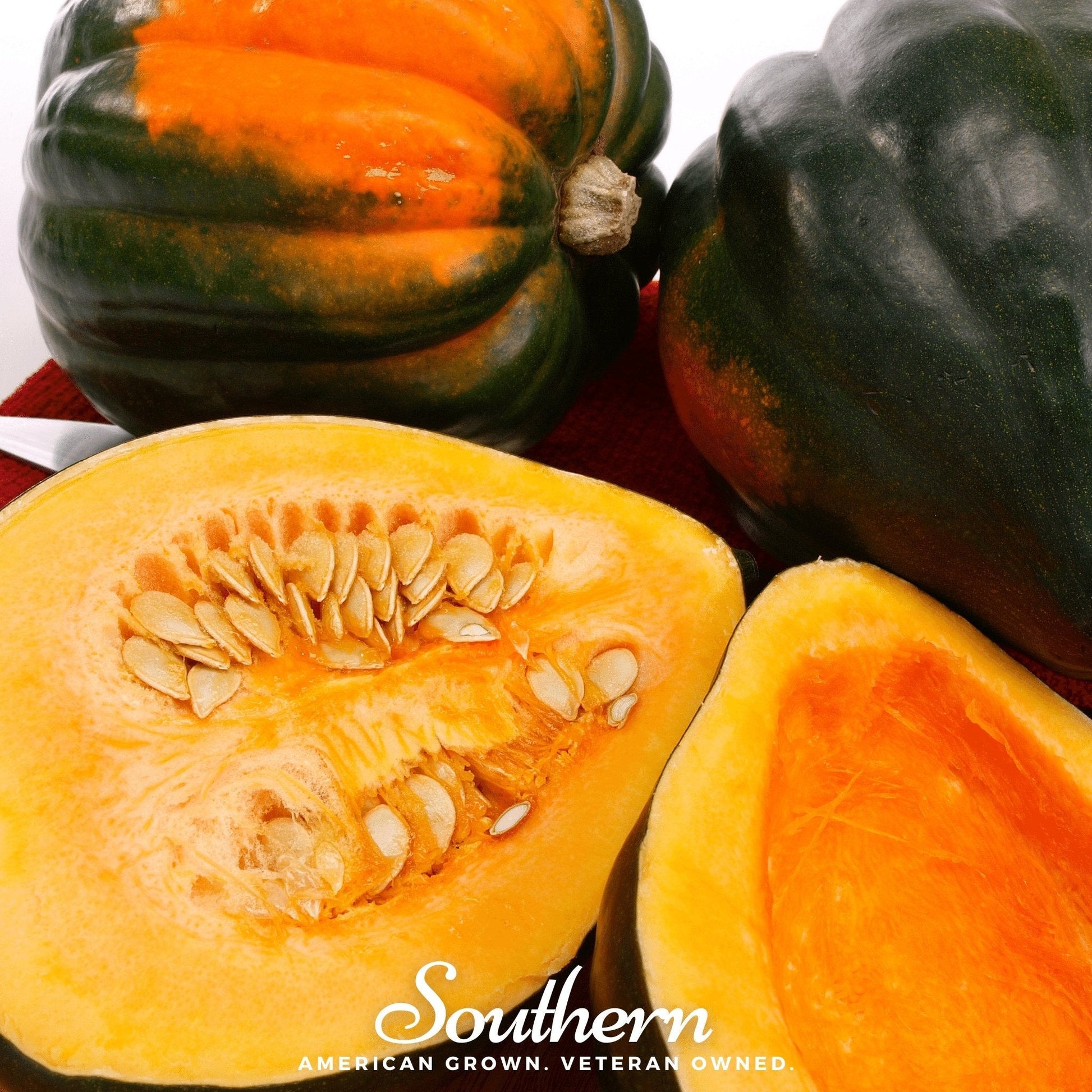 Acorn squash with a cut open showing seeds, surrounded by whole acorn squashes on a white background.