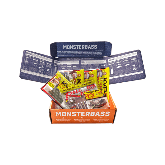 Monsterbass fishing lure box with open lid showing contents on a green background