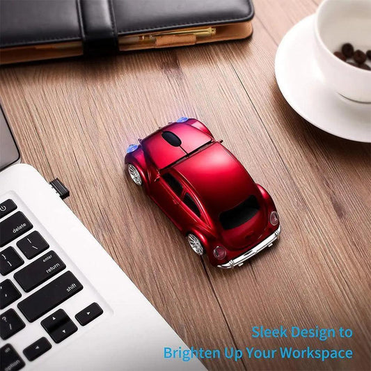 Red car-shaped mouse on a wooden desk with a laptop and coffee cup in the background.