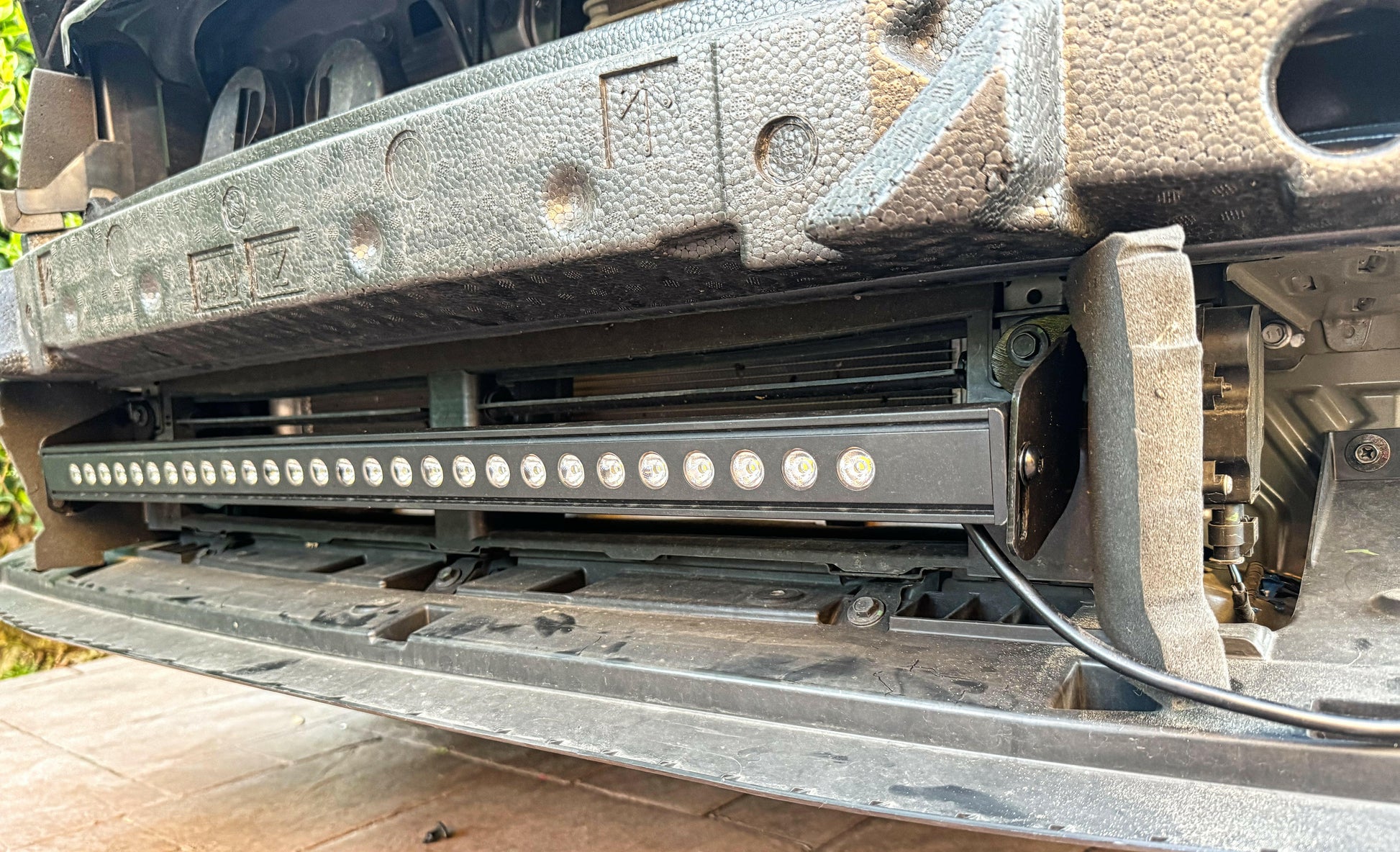 Close-up of a vehicle's undercarriage with a light bar attached