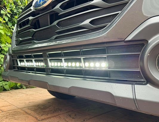 Close-up of a car's front grille with visible LED lights on a tiled floor.