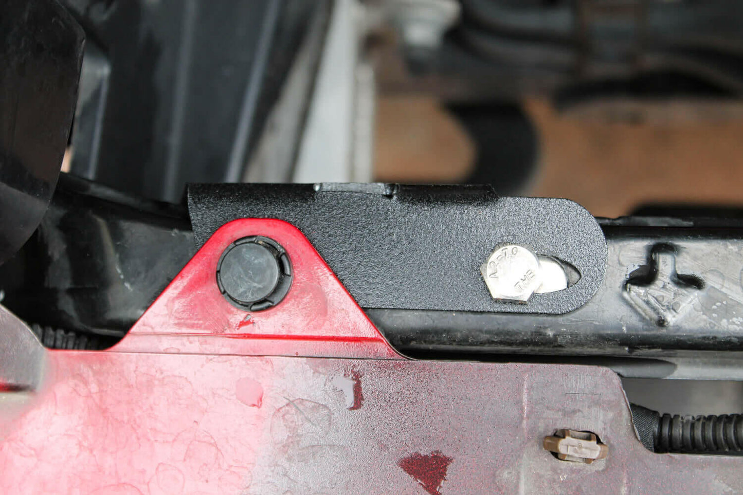 Close-up of a red and black mounting Bracket with a blurred background