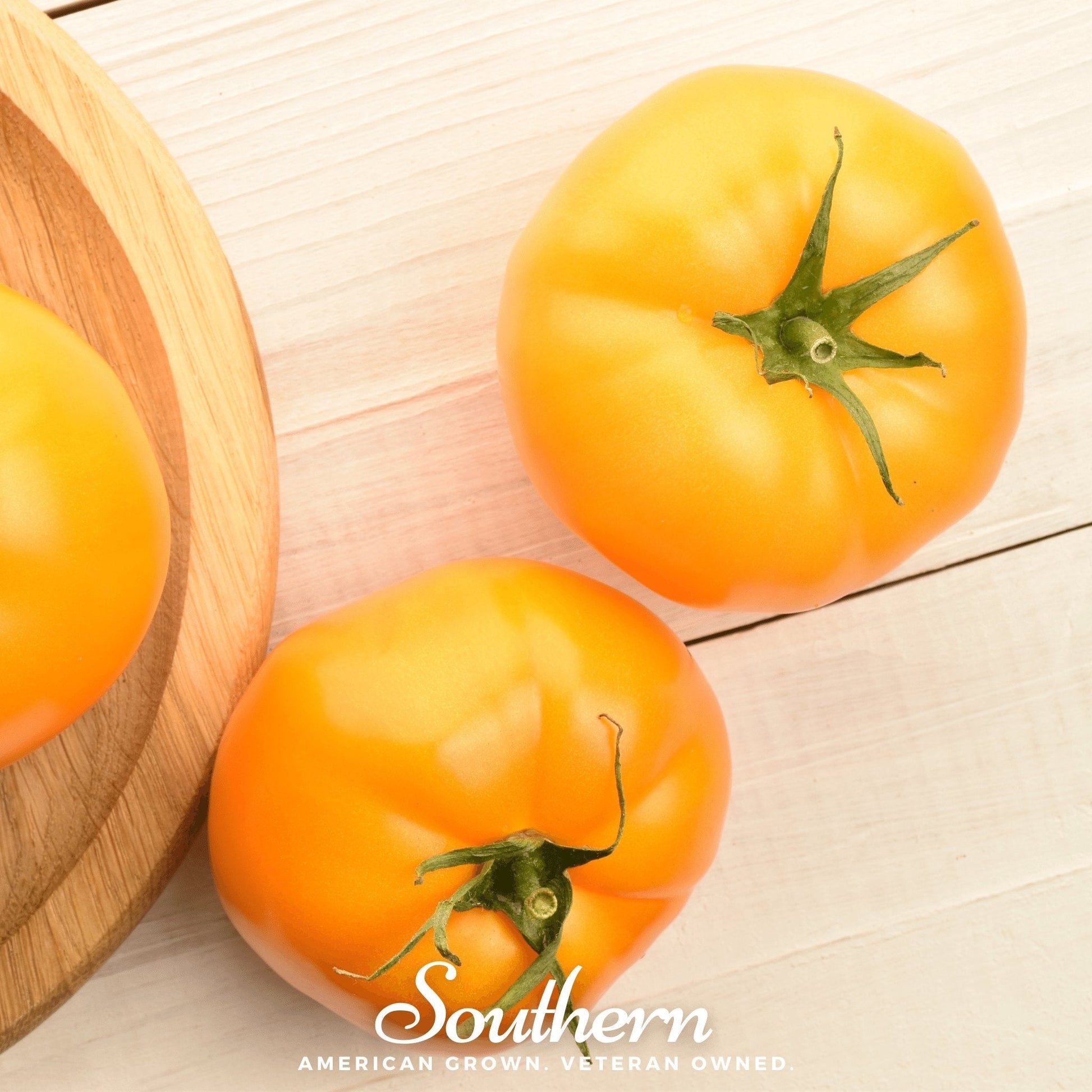 Two orange tomatoes on a wooden surface with 'Southern' branding.