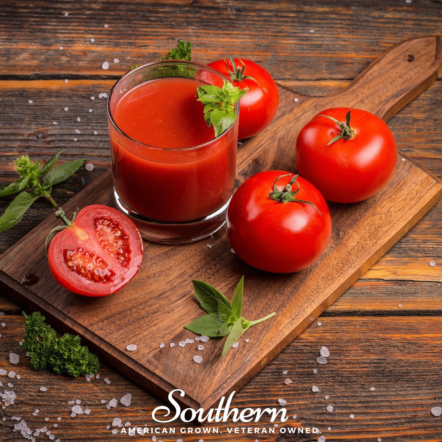 Glass of tomato juice on a wooden cutting board with fresh tomatoes and basil leaves, featuring 'Southern' brand.