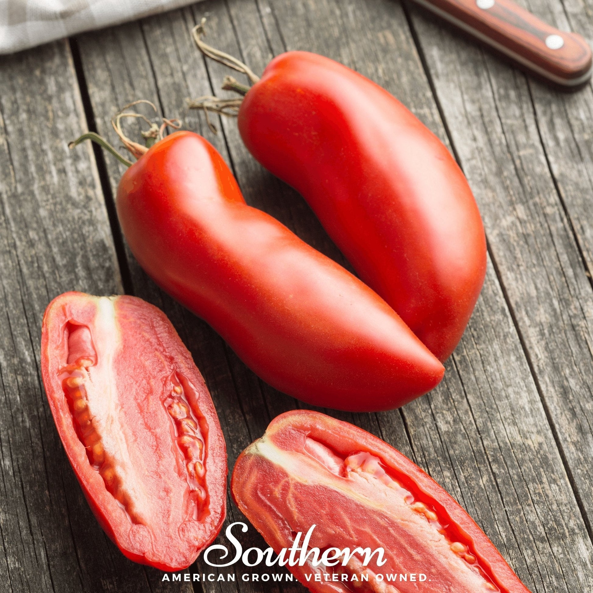 Two whole red plum tomatoes and one sliced on a wooden surface with 'Southern' brand text.