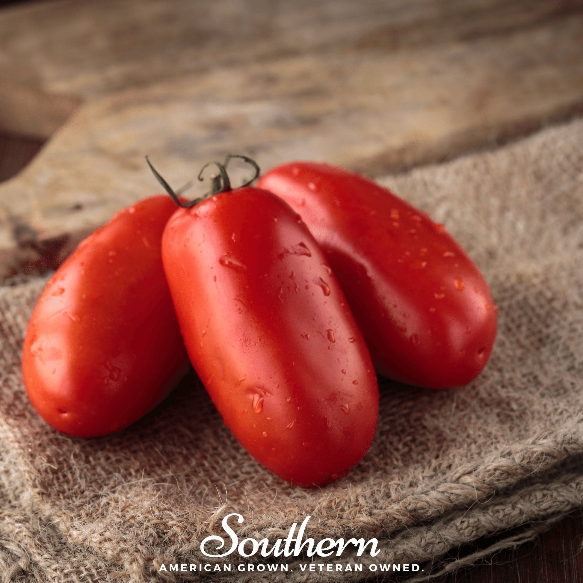 Three red plum tomatoes on a rustic surface with 'Southern' branding.