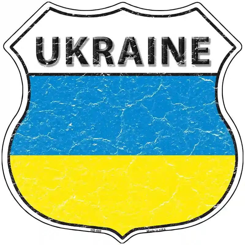 Shield-shaped sign with the word UKRAINE at the top and the blue-and-yellow Ukrainian flag filling the lower half, shown on a white background.