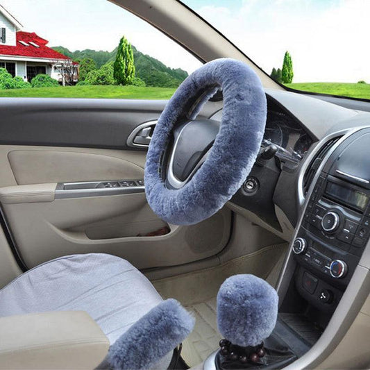 Car interior with a blue steering wheel cover and gear shift boot in a vehicle parked outdoors.