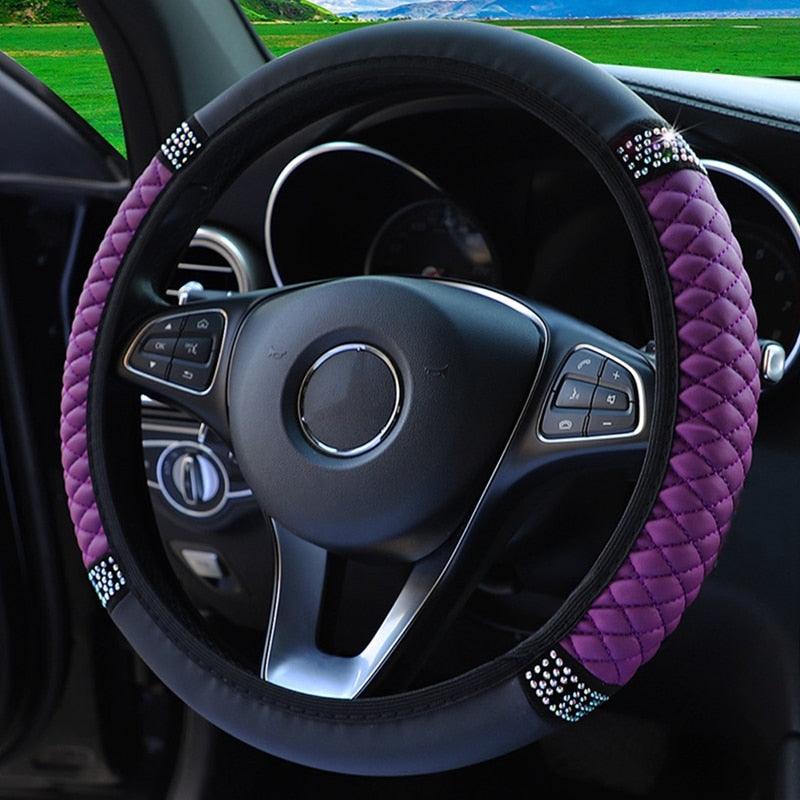 Steering wheel with purple cover and decorative elements inside a car.